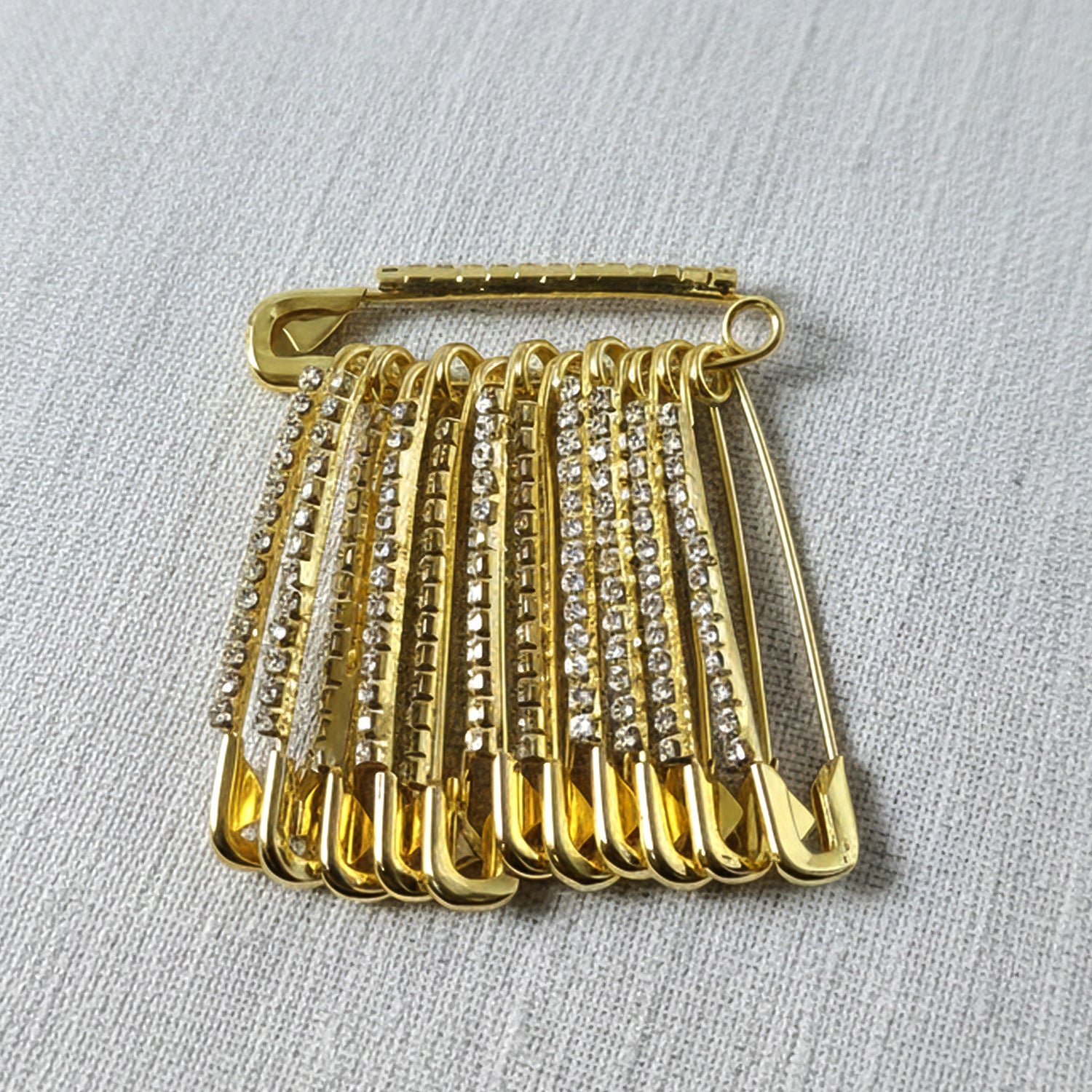 03_28d5a2cf-3b75-4570-967a-368230835652 Golden Safety Pin Brooch Set – Elegant Stone-Embedded Design
